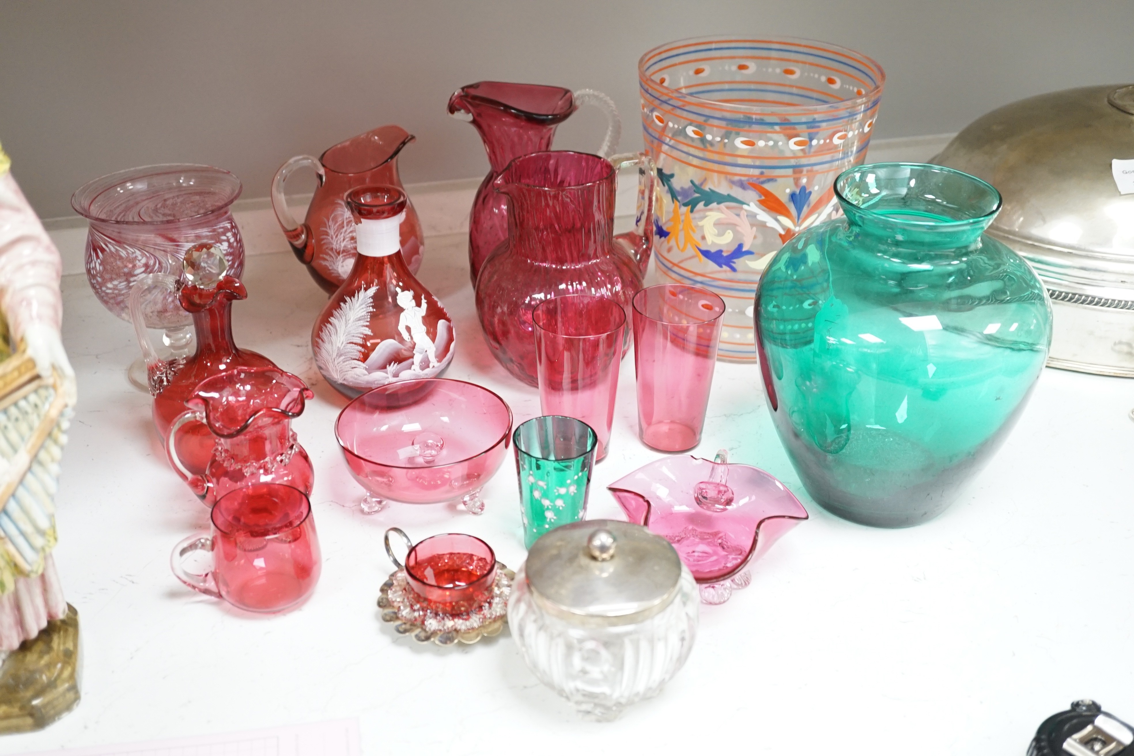 A collection of cranberry glass, a silver lidded glass sugar bowl, and enamelled glass historismus humpen etc